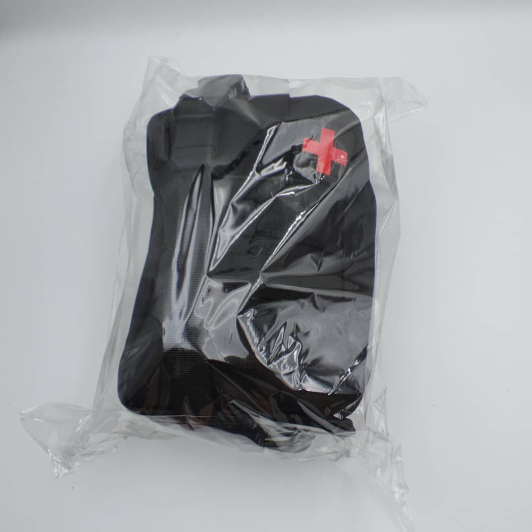 Compact black first aid pouch in protective packaging for workplace, travel and outdoor safety kits.